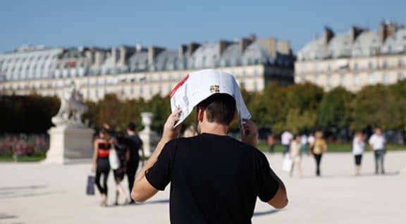 Un automne caniculaire à Paris, Parisien qui se couvre la tête au jardin du Luxembourg